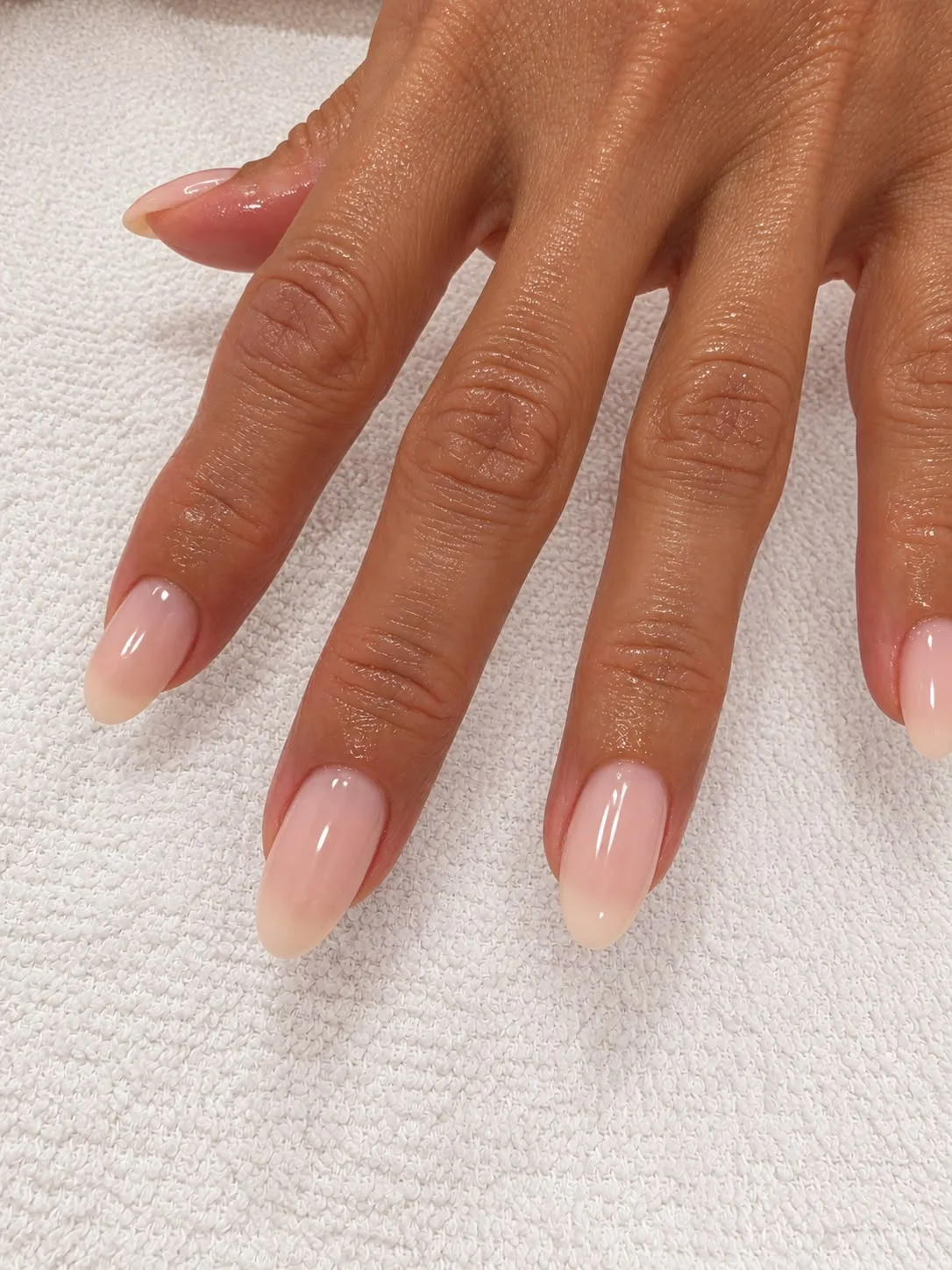 Polished natural nails with a soft sheer color finish